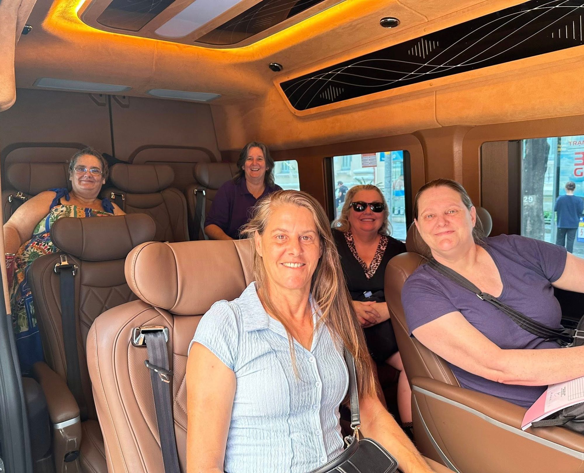 Five-happy-female-tourists-smiling-while-enjoying-a-comfortable-ride-inside-a-luxury-limousine-van-in-Hanoi-Vietnam