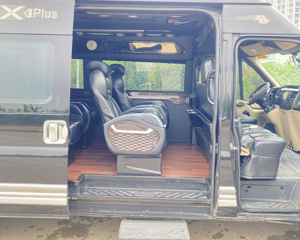 Open side door of a Ford limo van having leather seats and wood-effect flooring