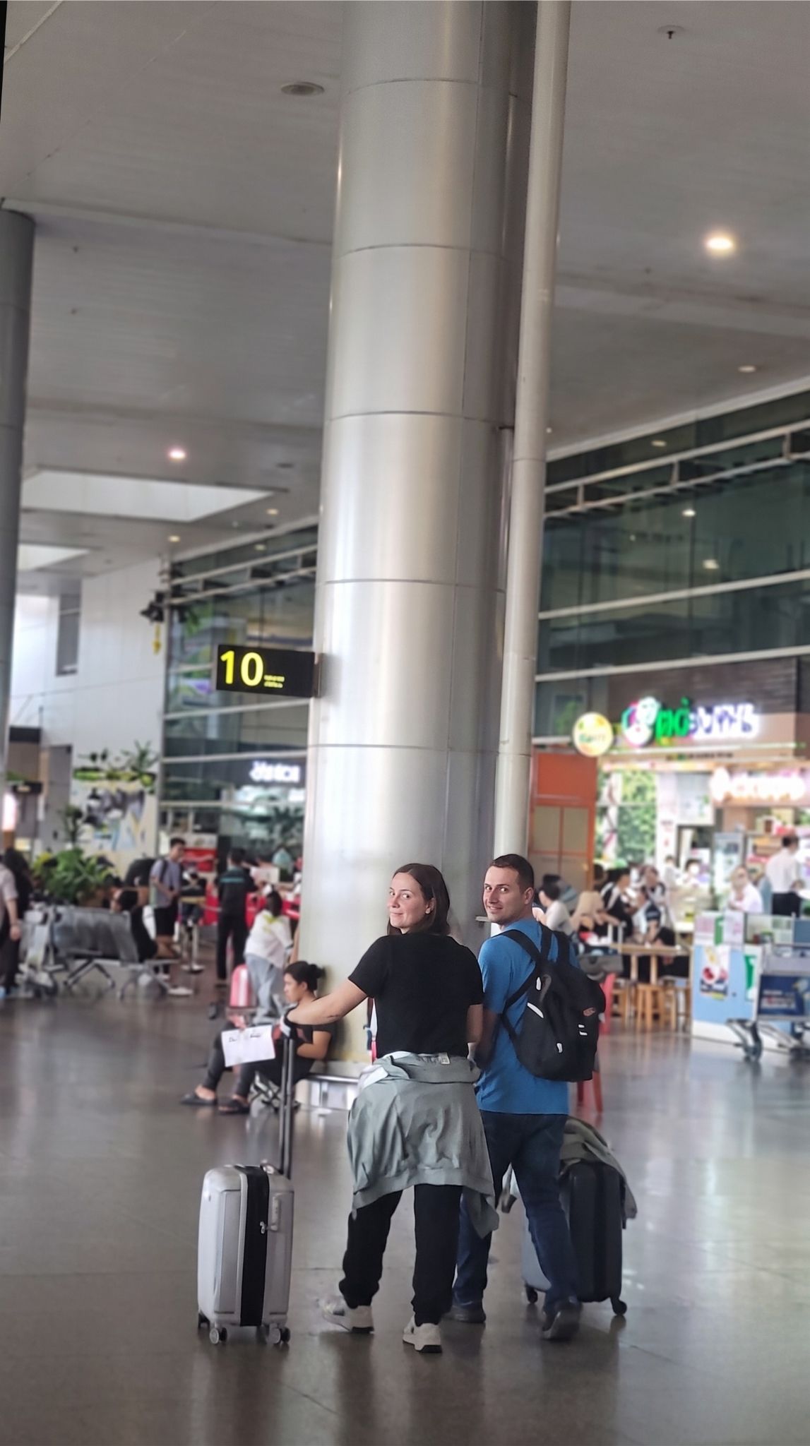 International-travelers-pulling-suitcases-past-Column-10-at-Tan-Son-Nhat-Airport-to-meet-their-private-transfer-driver