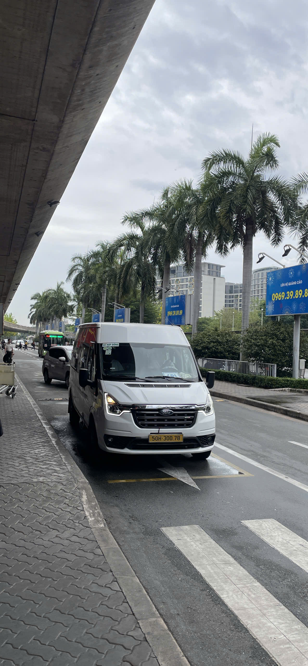 White-Ford-Transit-16-seater-van-waiting-for-airport-pickup-service-at-the-terminal