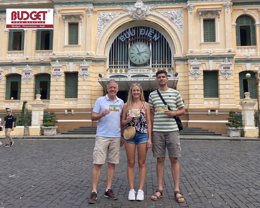 A-group-of-travelers-posing-outside-the-famous-yellow-French-colonial-architecture-of-the-Central-Post-Office