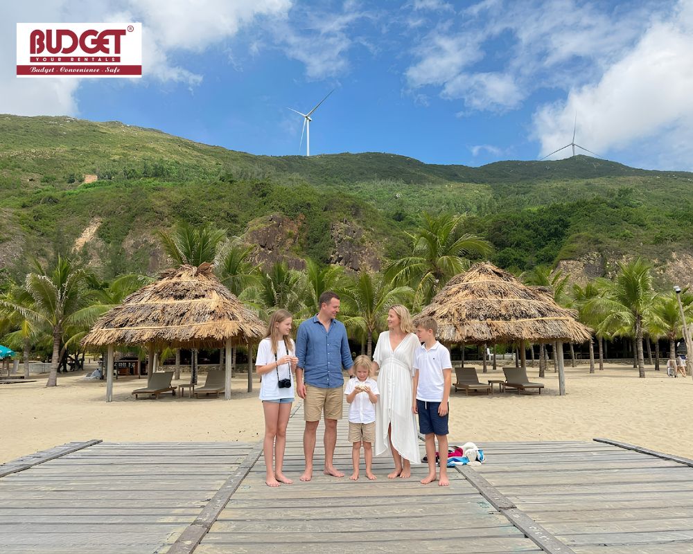 A-happy-family-standing-on-a-wooden-pathway-at-Ky-Co-beach