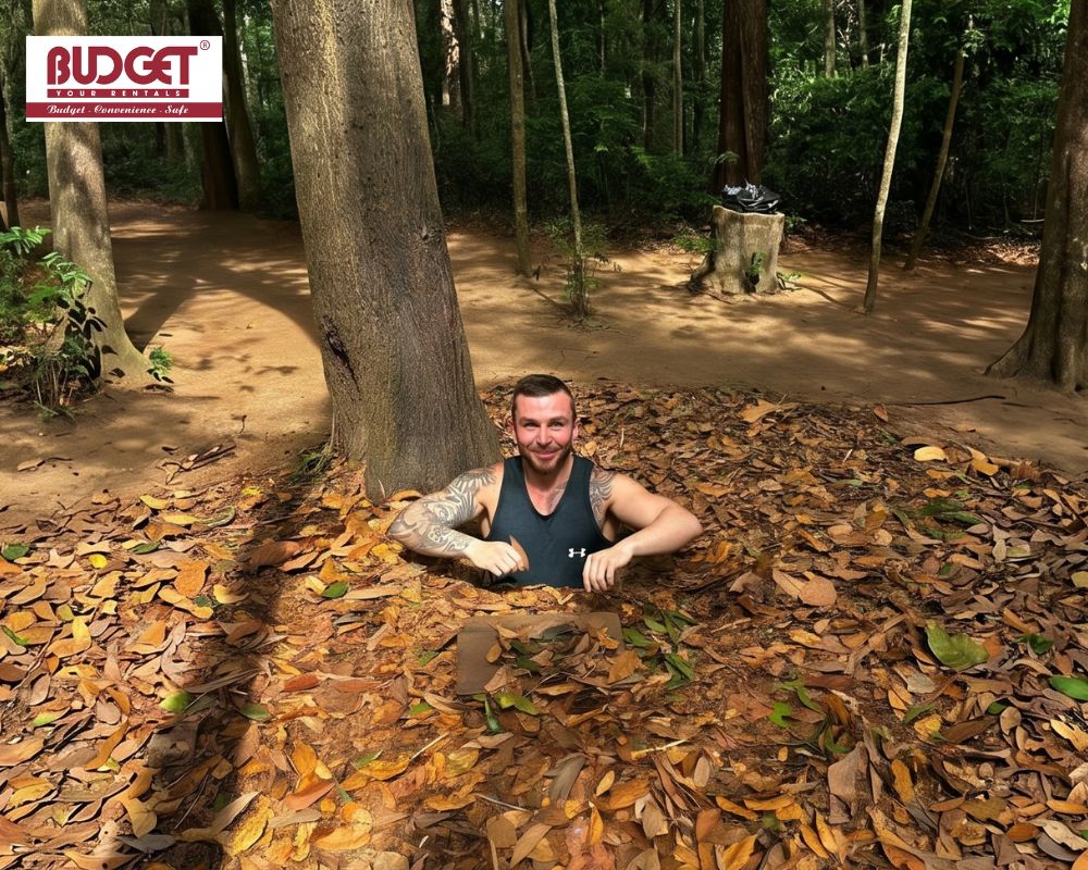A-man-experiencing-a-small-leaf-covered-camouflaged-tunnel-entrance-at-the-Cu-Chi-Tunnels