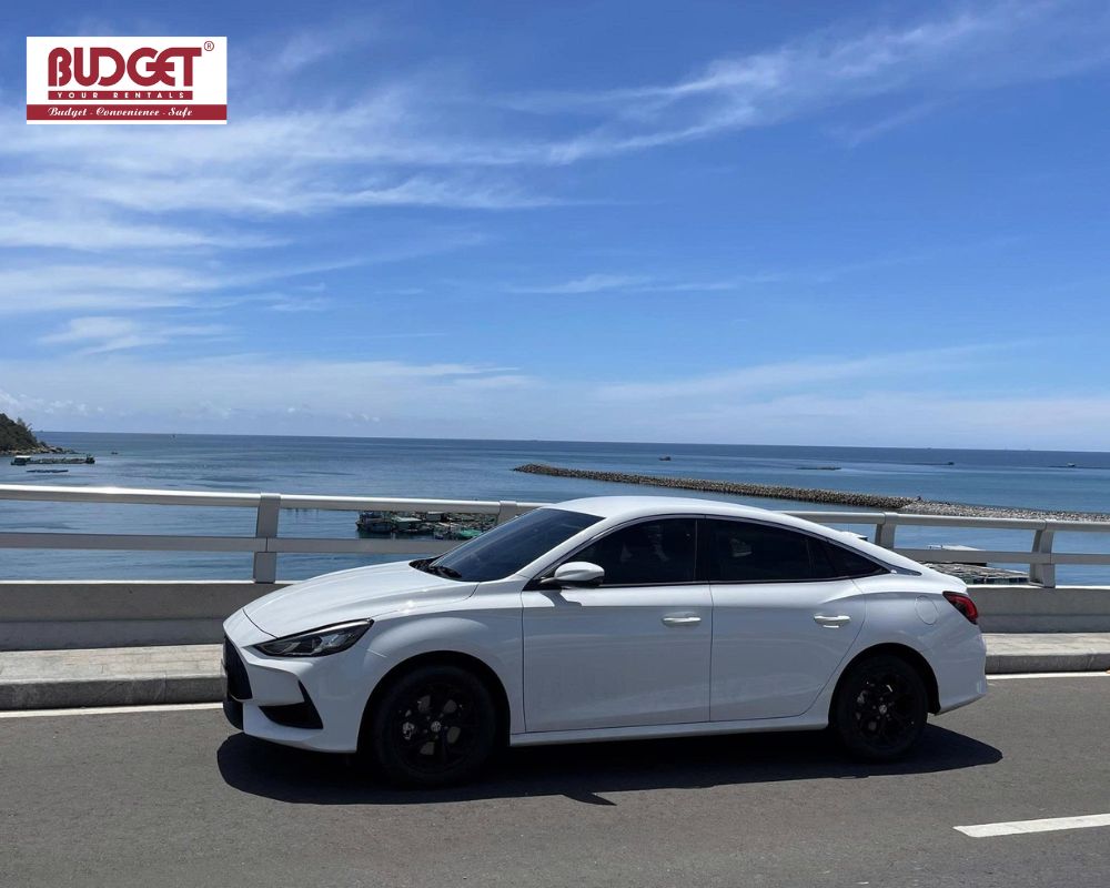 A-white-MG-sedan-parked-on-a-coastal-bridge