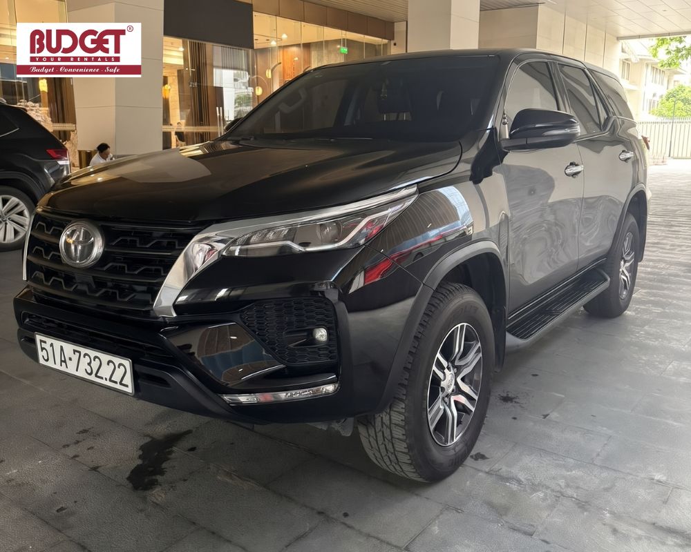 Black-Toyota-Fortuner-SUV-for-private-airport-transfers-waiting-at-a-hotel-entrance-in-Ho-Chi-Minh-City