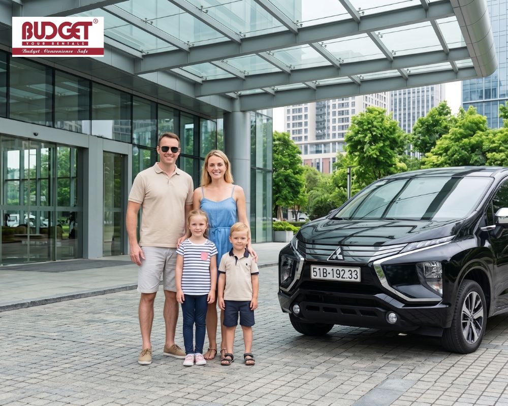 Foreign-family-posing-next-to-a-black-7-seater-Mitsubishi-Xpander-private-rental-car-outside-a-city-hotel