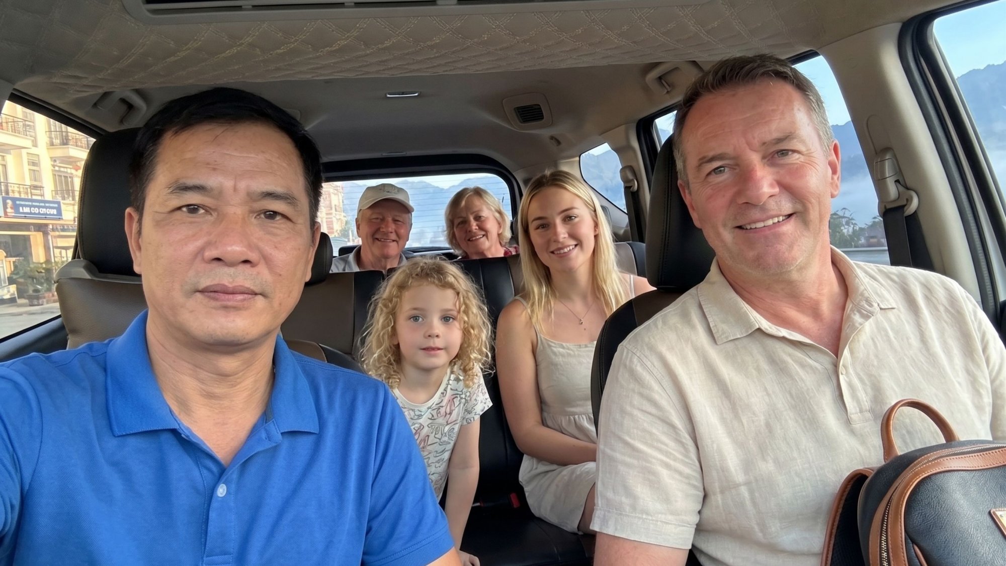 Friendly-local-driver-taking-a-selfie-with-a-foreign-tourist-family-inside-their-Ha-Giang-car-rental