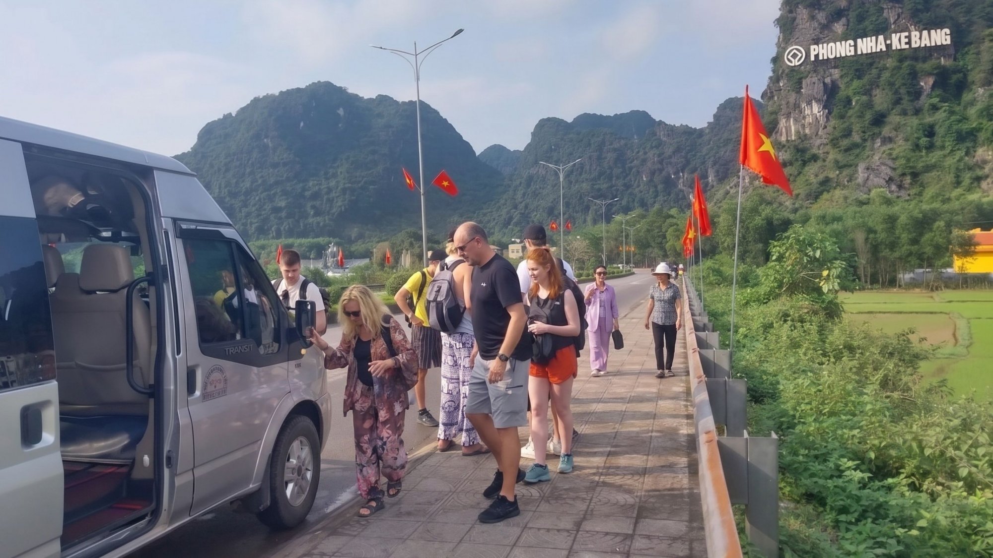 Group-of-international-travelers-taking-a-scenic-road-tour-in-a-grey-transit-van-at-Phong-Nha-Ke-Bang