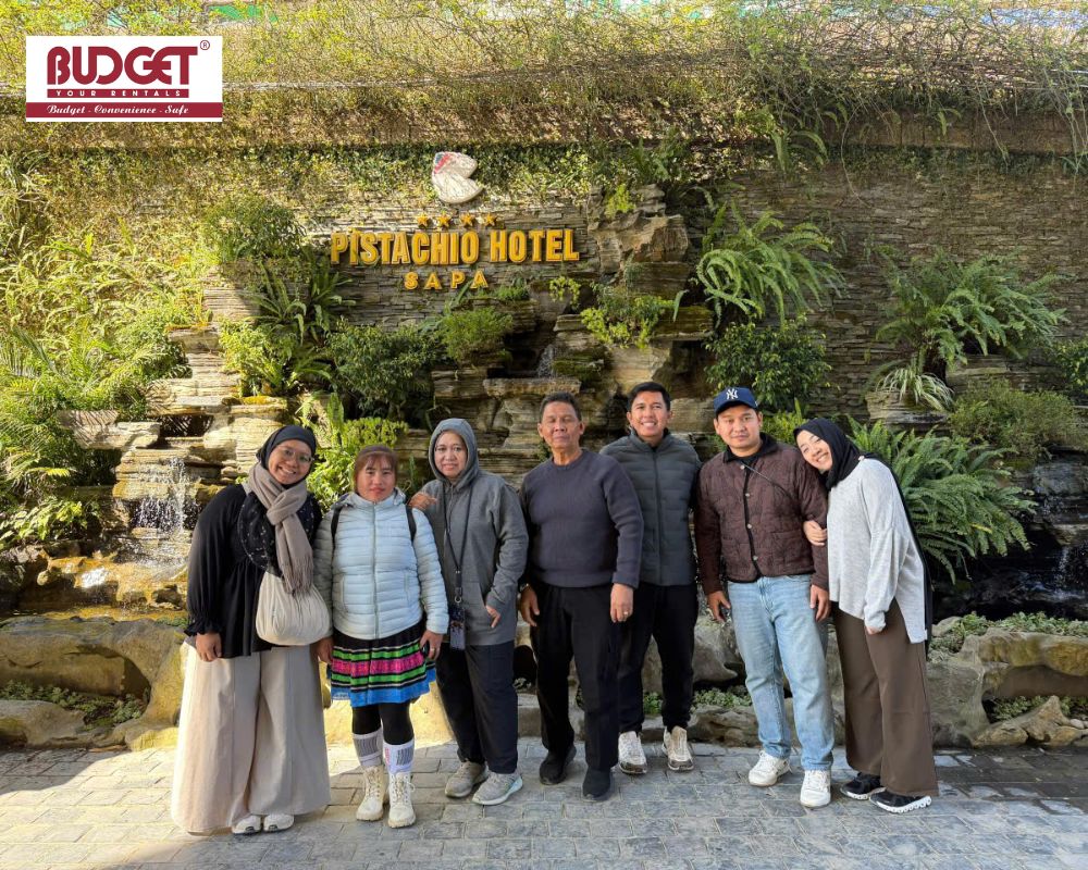 Group-of-travelers-posing-in-front-of-Pistachio-Hotel-Sapa-after-arriving-with-a-private-car-rental-service