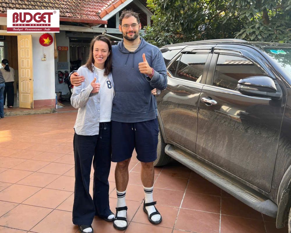 Happy-foreign-couple-posing-with-their-private-car-and-driver-during-a-customized-trip-in-Northern-Vietnam