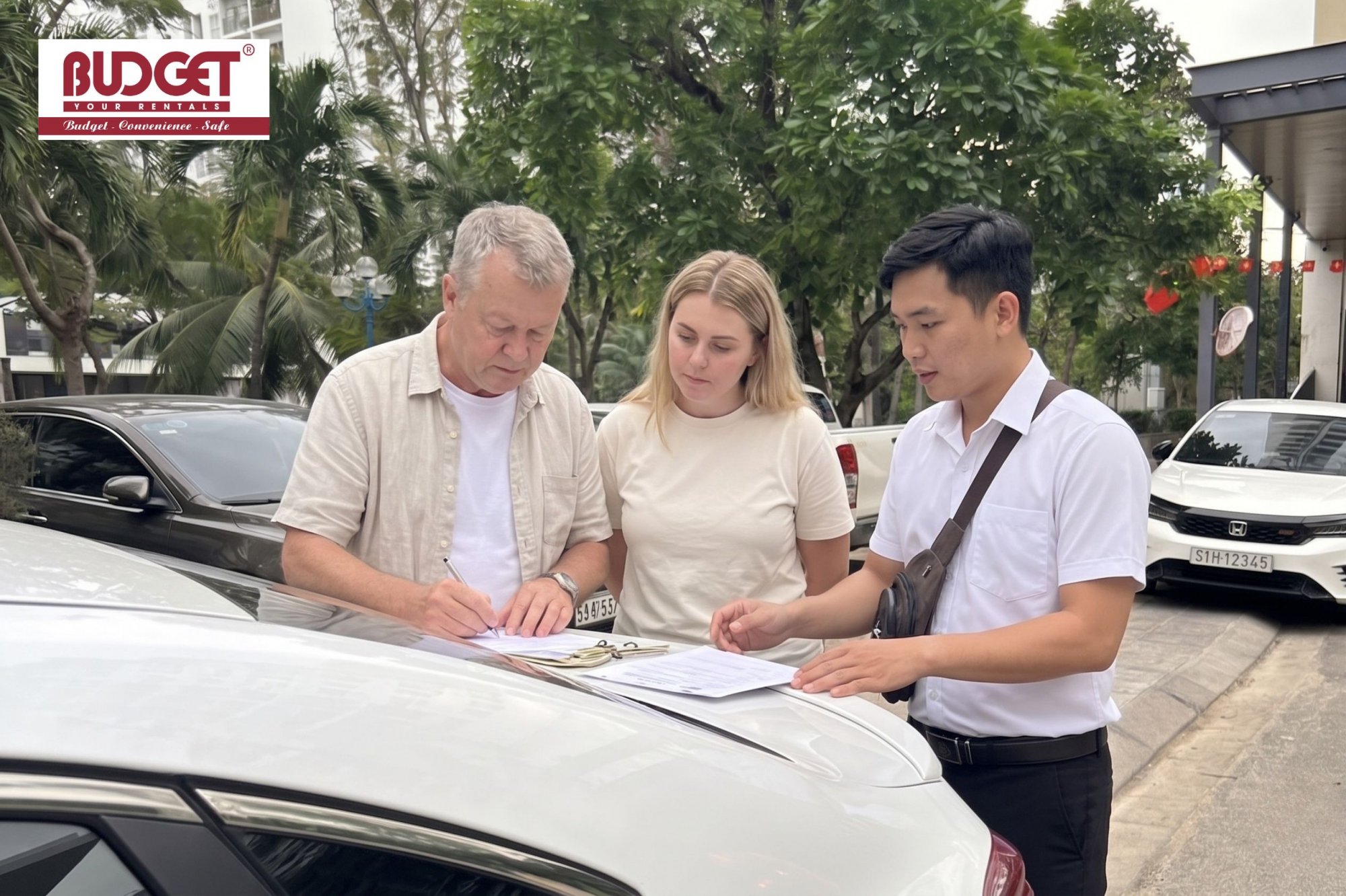 International-customers-completing-a-vehicle-rental-contract-with-a-Vietnam-Budget-Car-Rental-driver