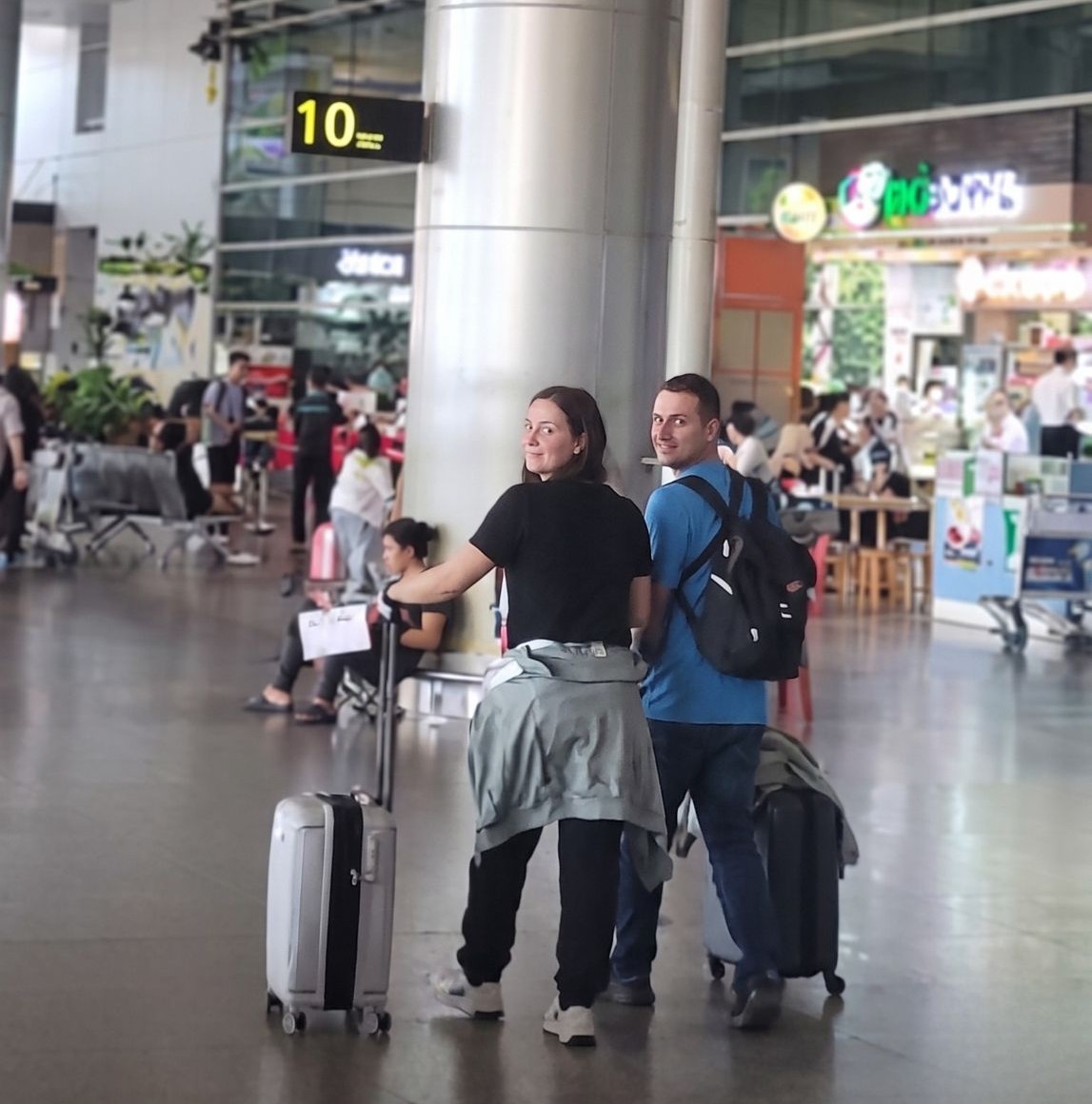 International-travelers-pulling-suitcases-past-Column-10-at-Tan-Son-Nhat-Airport-to-meet-their-private-transfer-driver