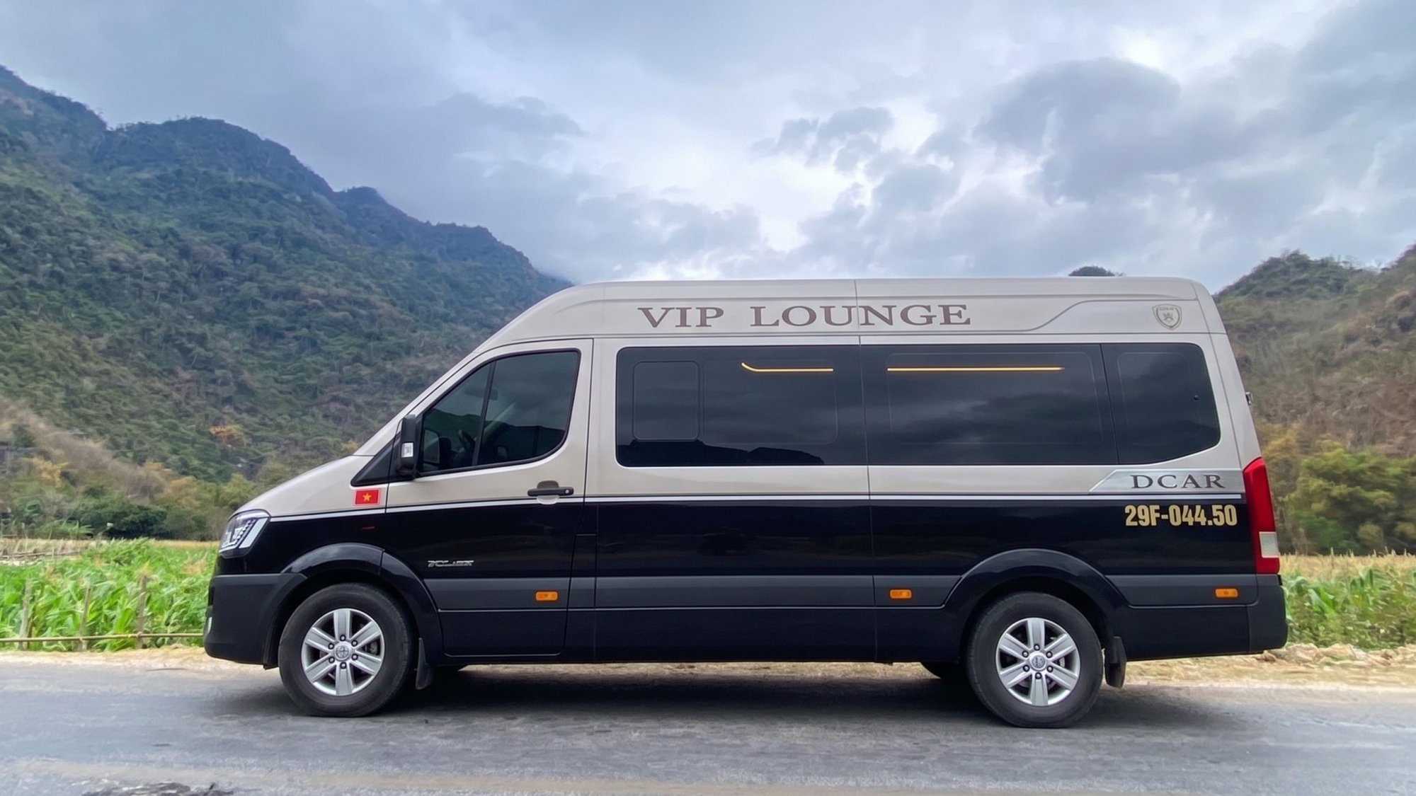 Luxury-DCAR-VIP-Lounge-limousine-van-parked-on-a-scenic-mountain-road-in-Ha-Giang