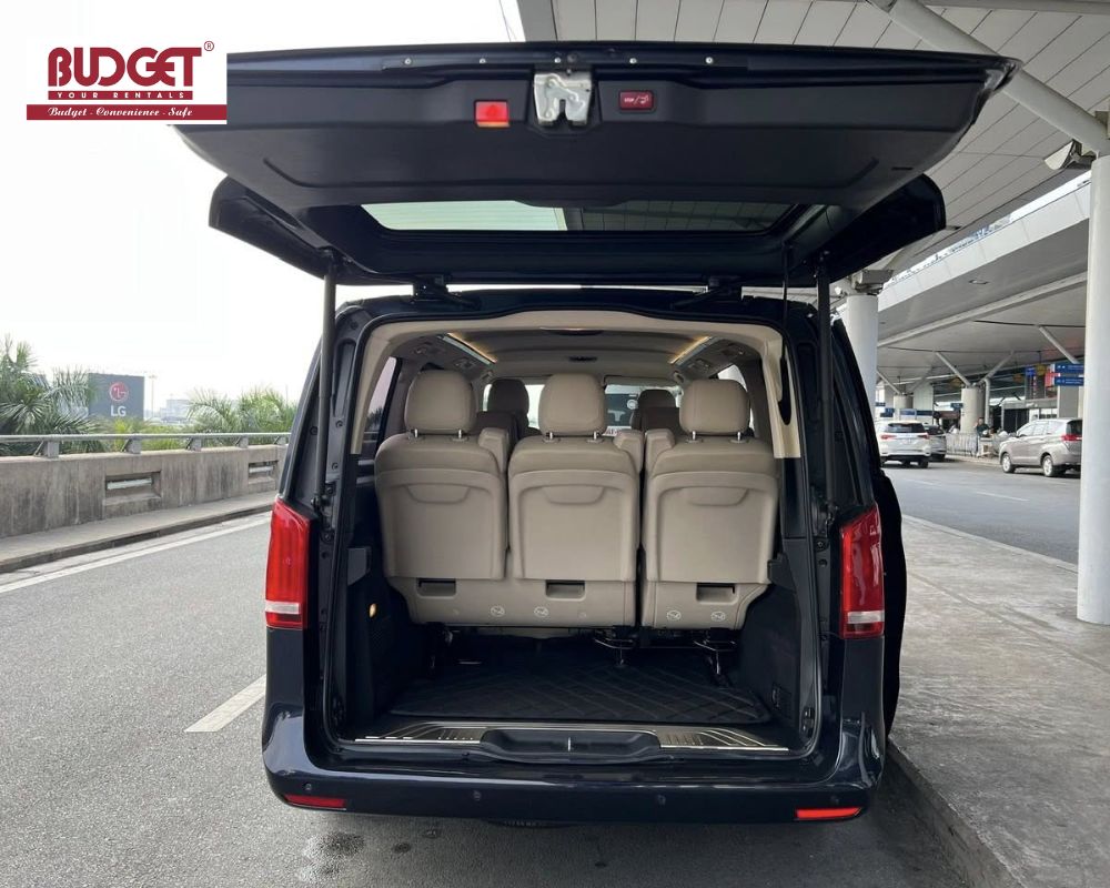 Spacious-7-seater-Mercedes-V250-with-open-trunk-showing-luggage-capacity-at-Ho-Chi-Minh-airport-drop-off-zone