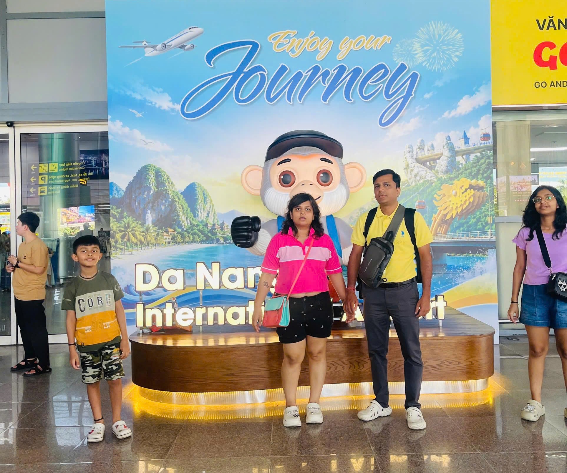 Tourist-family-taking-a-souvenir-photo-at-the-Da-Nang-International-Airport-welcome-sign-upon-arrival-for-our-private-transfer
