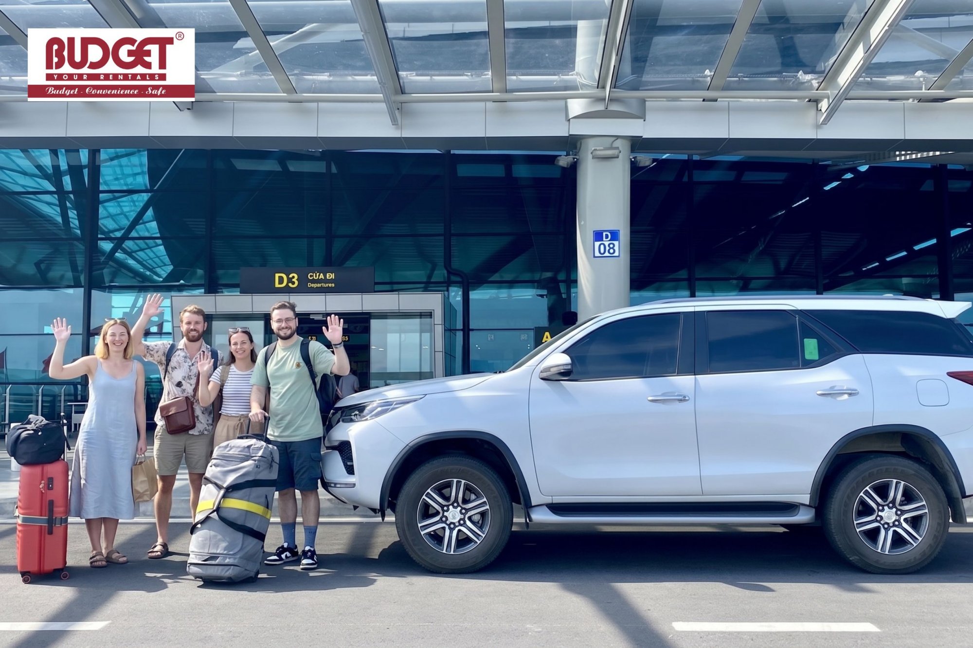 Tourists-with-luggage-waving-next-to-our-white-private-transfer-SUV-at-Danang-airport-departure-hall
