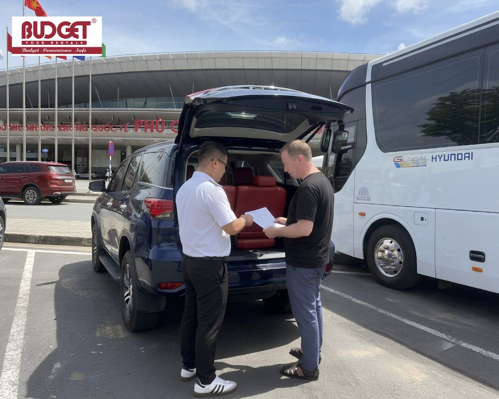Vietnam-Budget-Car-Rental-staff-handing-over-a-self-drive-car-rental-contract-to-a-customer-at-Phu-Quoc-Airport