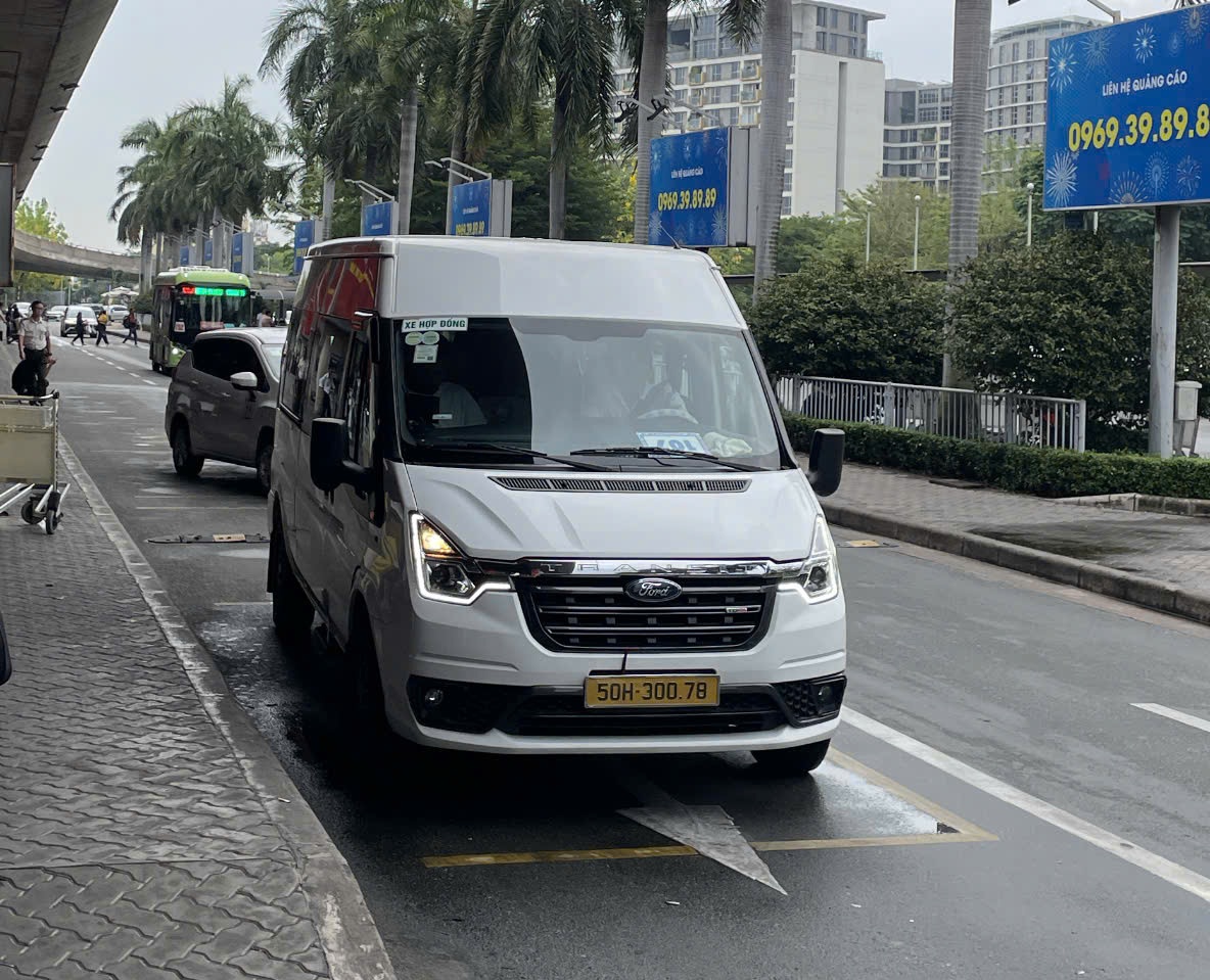 White-Ford-Transit-16-seater-van-waiting-for-airport-pickup-service-at-the-terminal-01