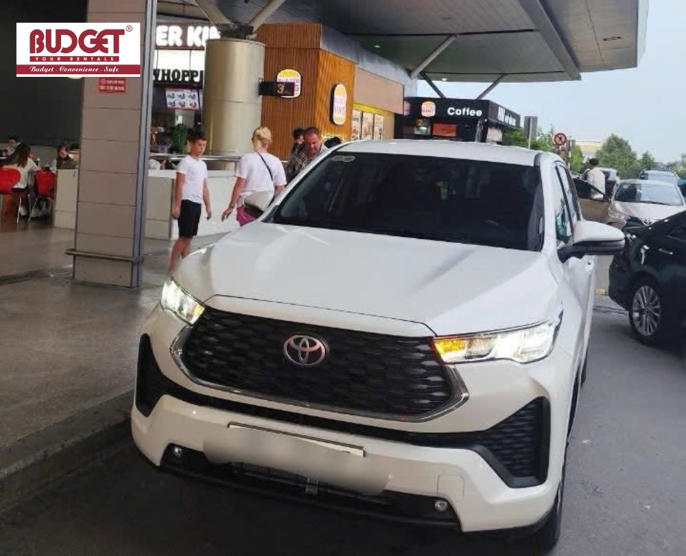 Private 7-seater white Toyota stopping at a highway rest area during a long-distance transfer from Nha Trang