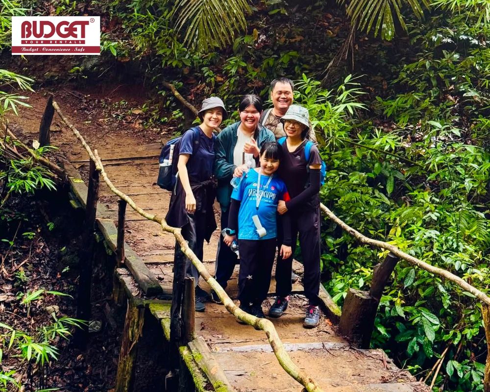 A-happy-family-posing-for-a-photo-on-a-wooden-forest-bridge-during-their-trekking-trip-in-Cat-Tien-National-Park
