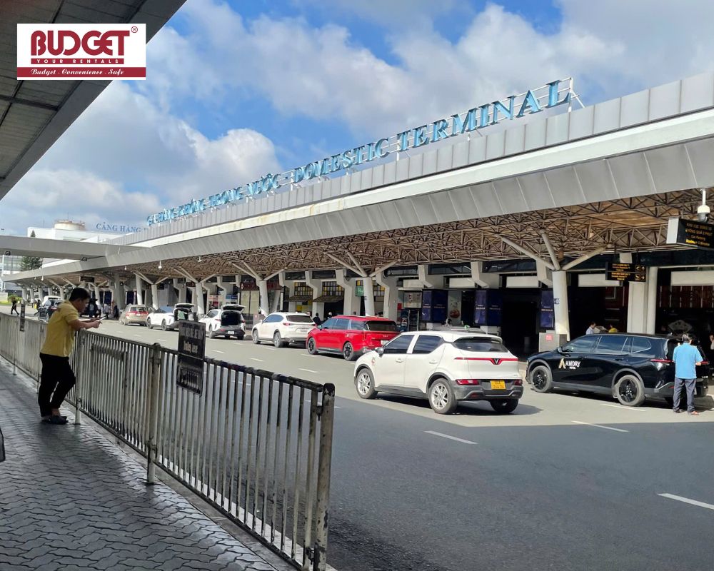 Exterior-view-of-a-busy-domestic-airport-terminal-in-Tan-Son-Nhat-airport-with-cars-and-SUVs-lined-up