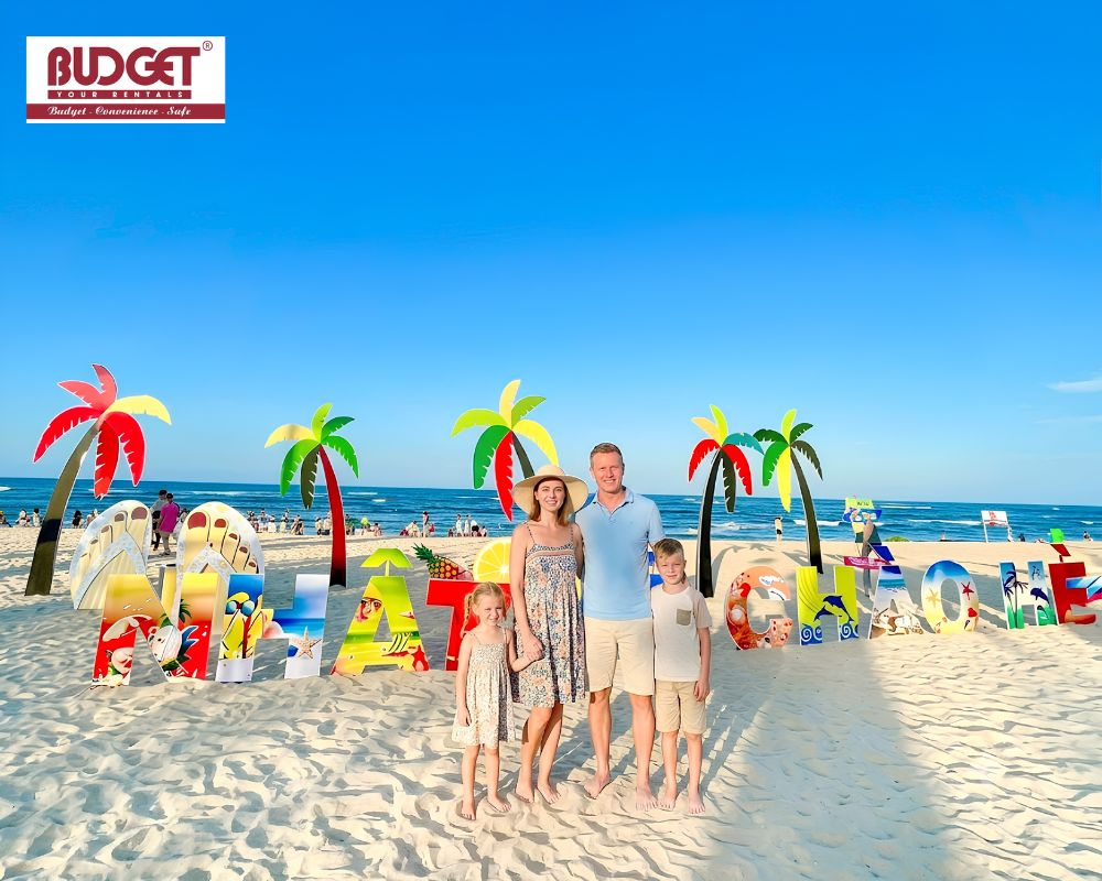 Family-posing-on-the-beautiful-white-sand-of-Nhat-Le-Beach-with-colorful-summer-decorations