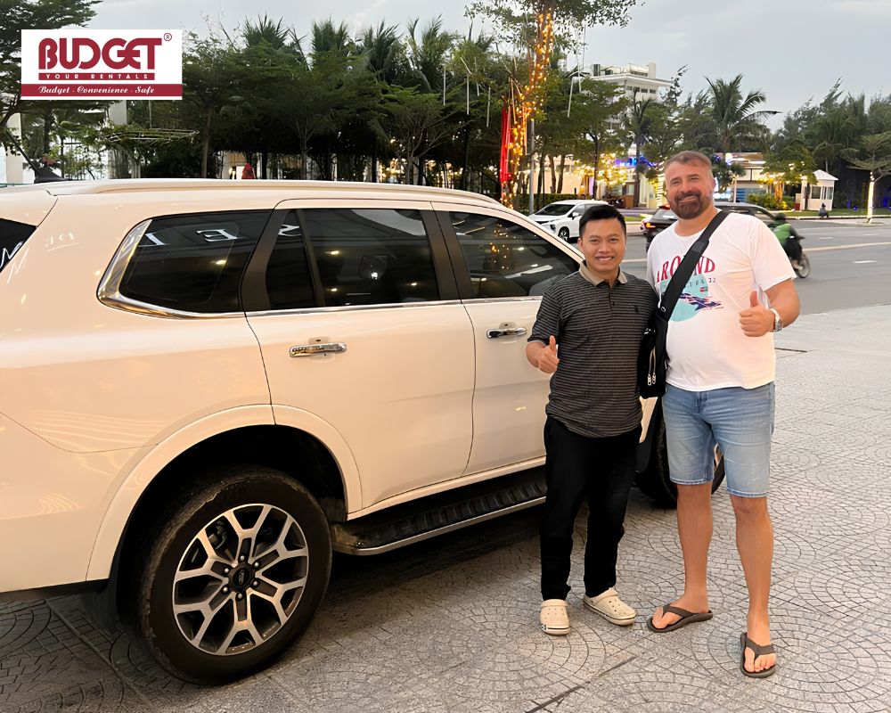 Our-friendly-driver-posing-with-a-USA-tourist-beside-a-white-7-seat