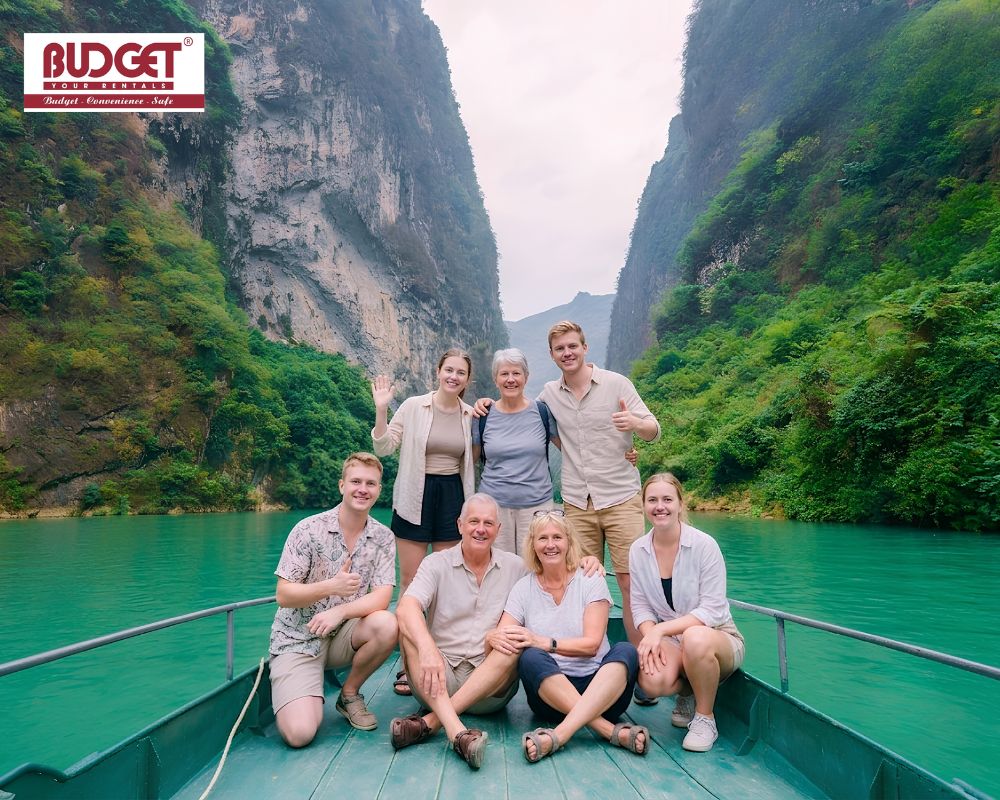 Smiling-family-and-friends-taking-a-sightseeing-boat-cruise-along-the-vibrant-emerald-Nho-Que-River