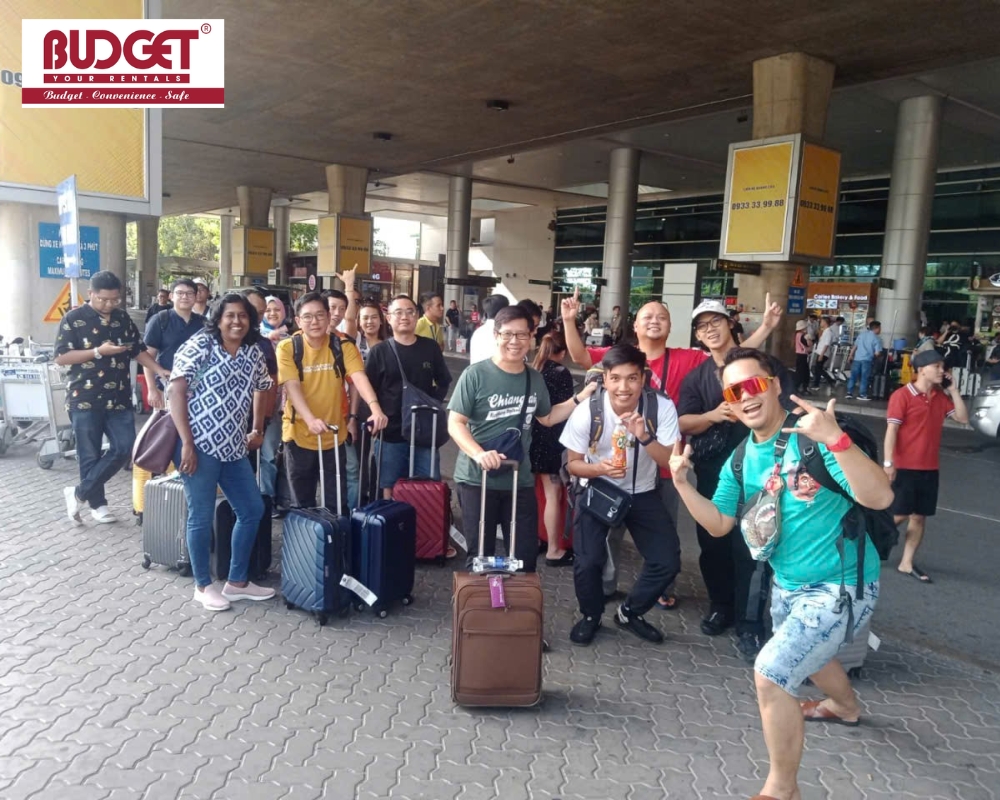 The group of tourists happily took photos at Tan Son Nhat Airport before boarding our private transfer