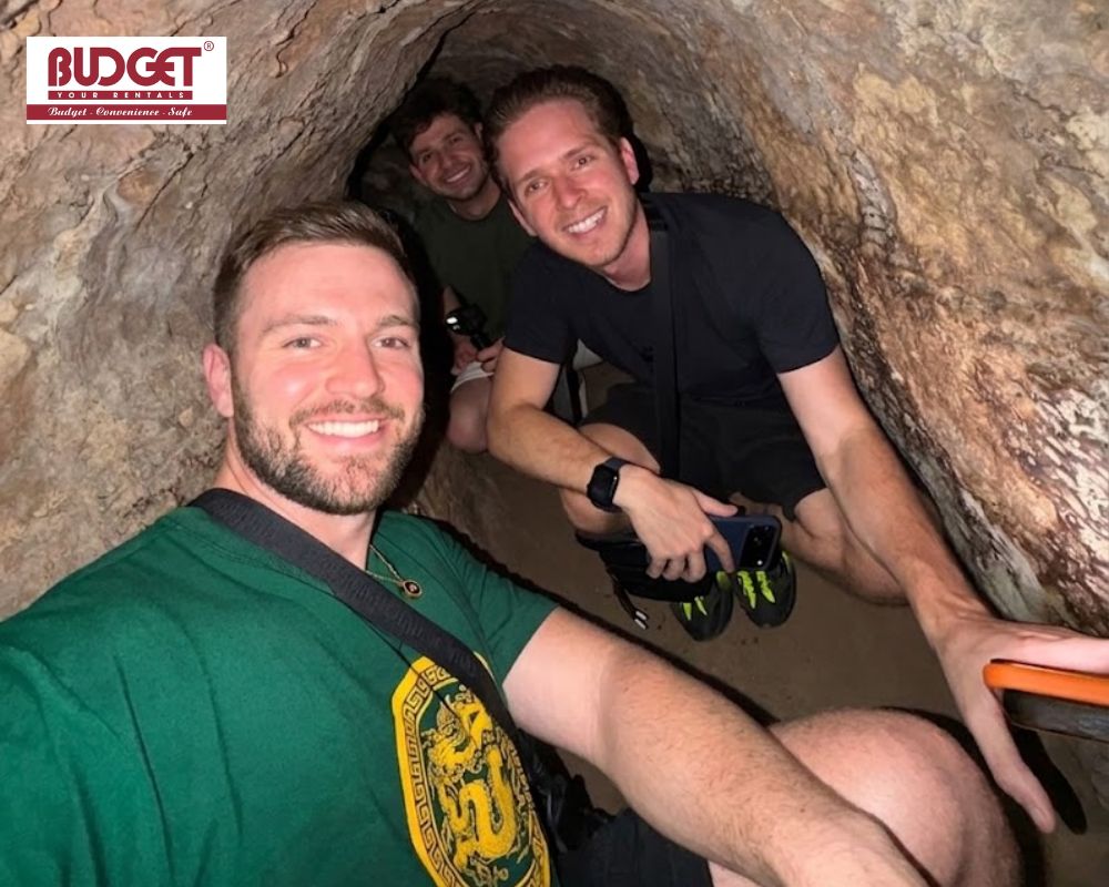 Three-man-navigating-the-famous-underground-dirt-passageways-at-Cu-Chi-Tunnels