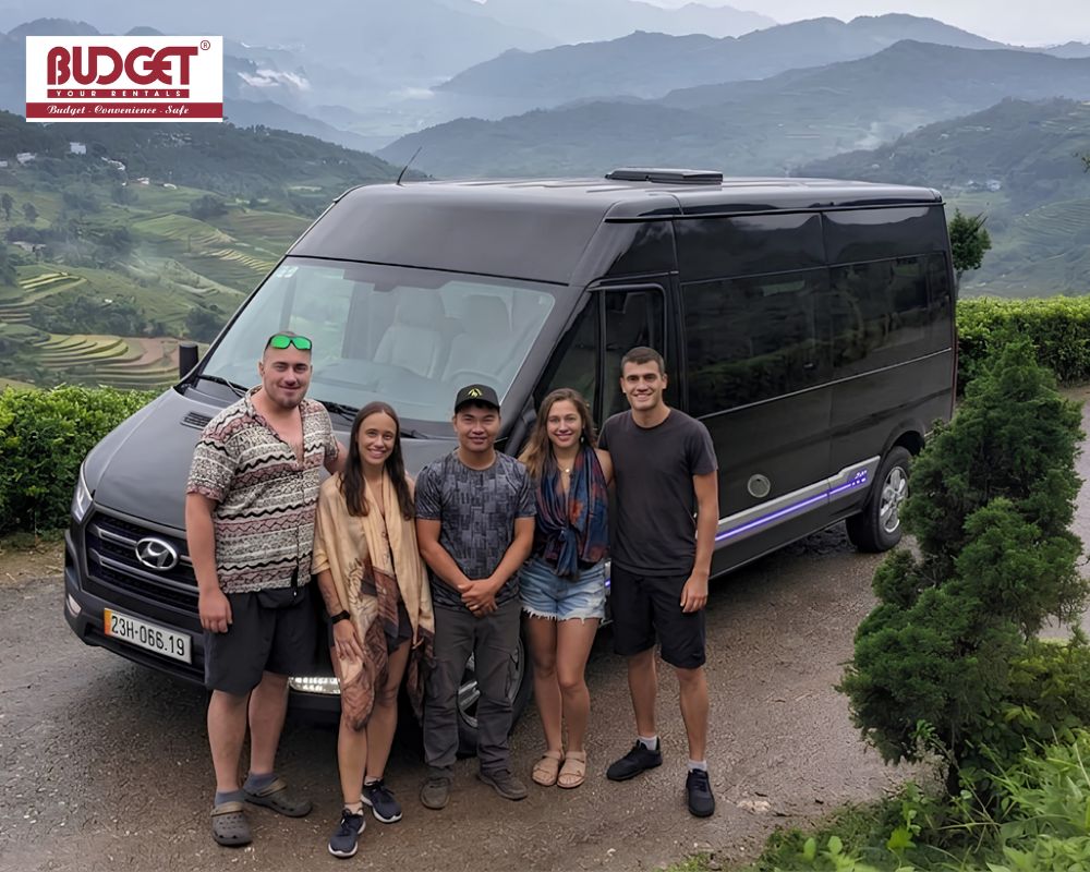 Travelers-and-our-local-driver-posing-next-to-a-black-Hyundai-transit-van-in-Ha-Giang