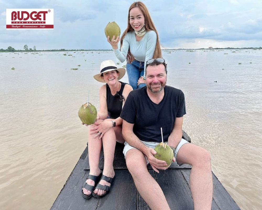 Travelers-relaxing-on-a-traditional-wooden-boat-while-enjoying-fresh-coconuts-with-our-local-guide