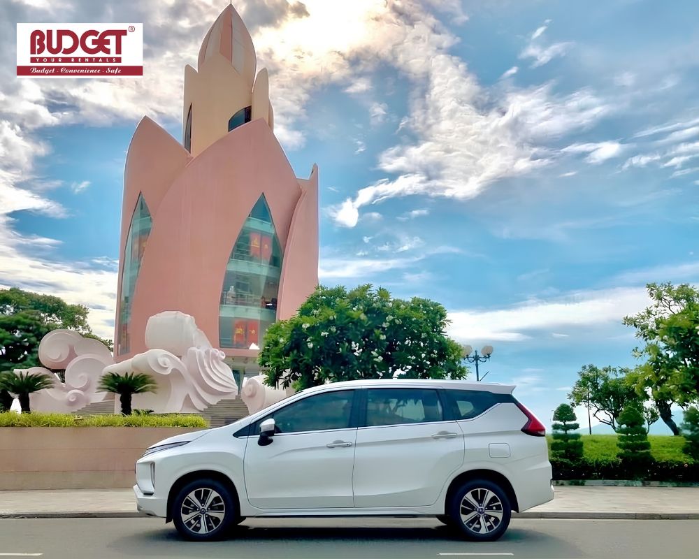 White-Mitsubishi-MPV-parked-in-front-of-the-iconic-pink-Tram-Huong-Tower