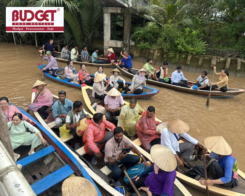 Tourists enjoying a scenic hand-rowed boat trip through the lush canals of Con Phung