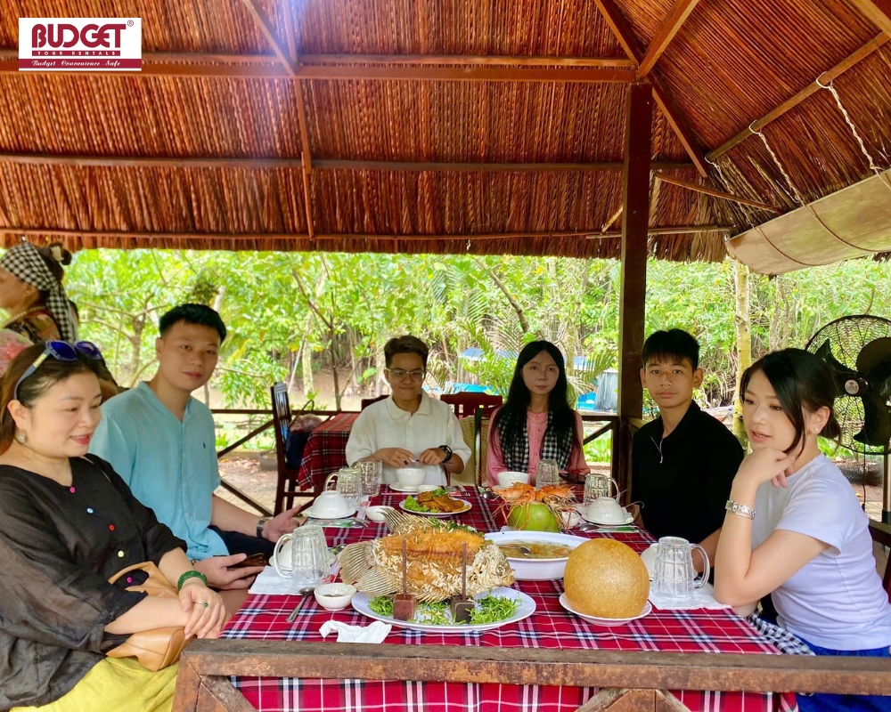 Visitors enjoy a traditional Mekong Delta lunch with local specialties at Con Phung Islet