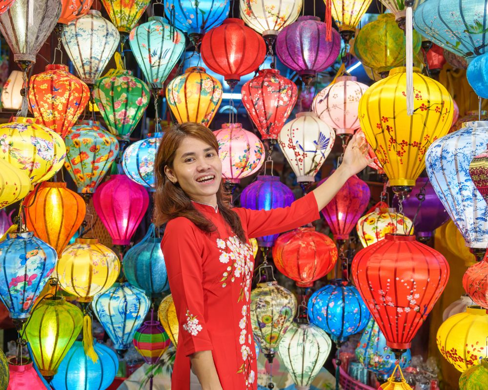 Woman wearing Ao Dai Vietnamese dress with colorful lanterns