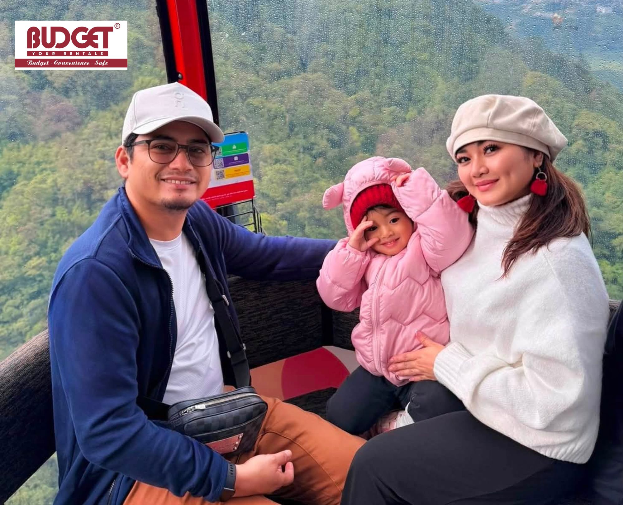 Happy-family-with-a-young-child-who-sits-inside-the-Fansipan-cable-car-cabin-high-above-green-valleys