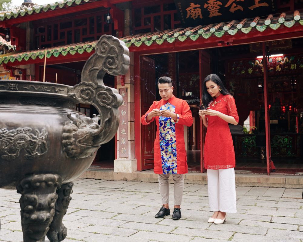 Young Vietnamese couple in traditional costumes praying