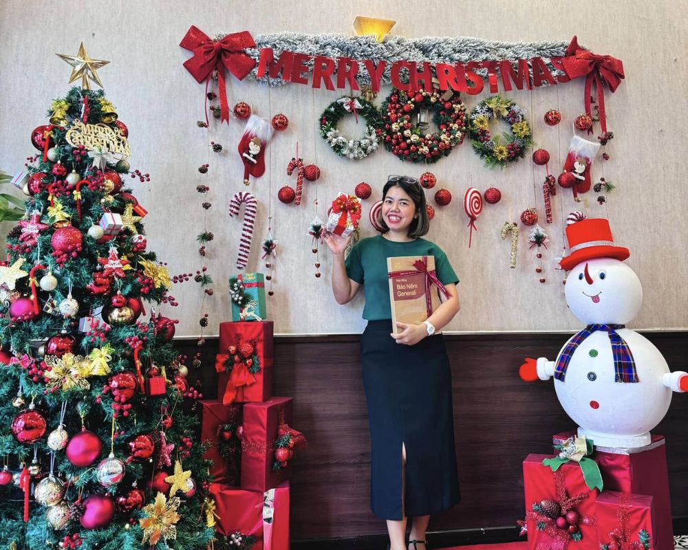 A cheerful woman poses with Christmas decorations