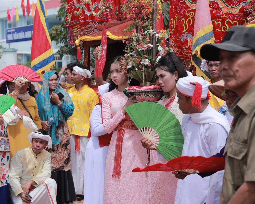 Procession with participants dressed in colorful attire, carrying offerings at the Kate festival