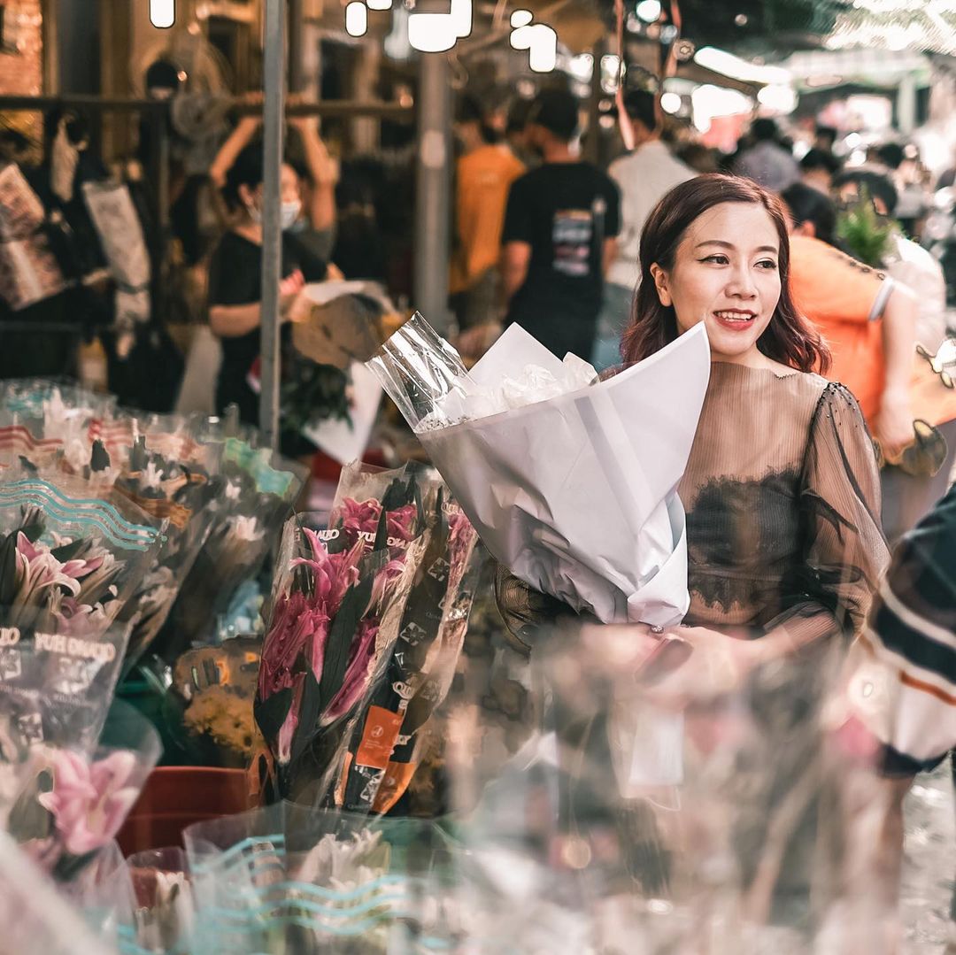 A woman is buying some flowers at the stall of Ho Thi Ky