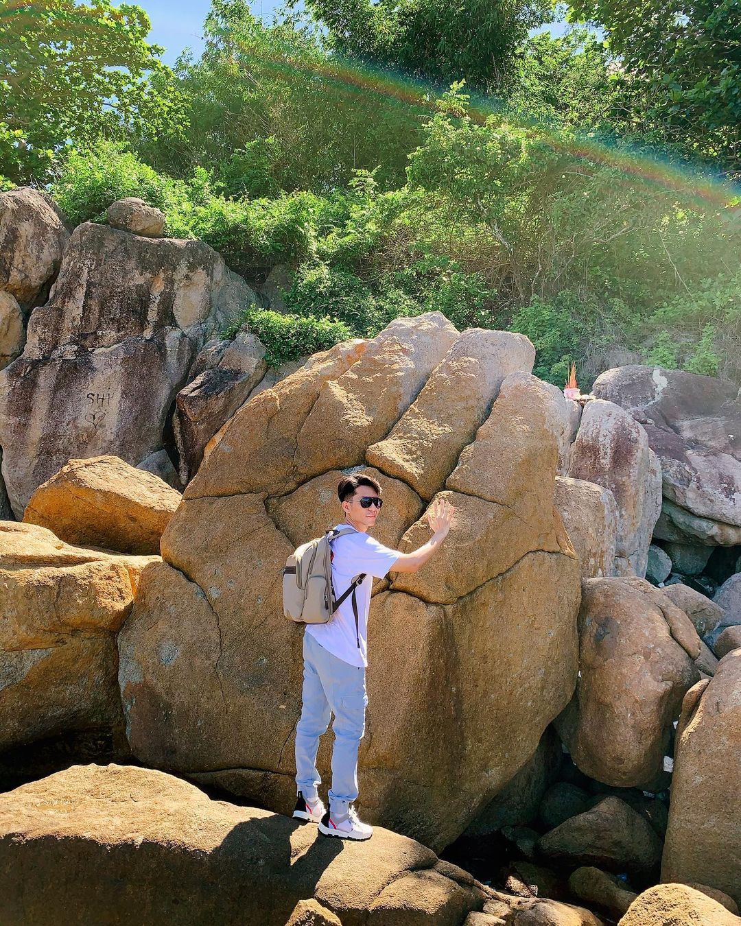 A man standing by the rocks of Da Bac Island